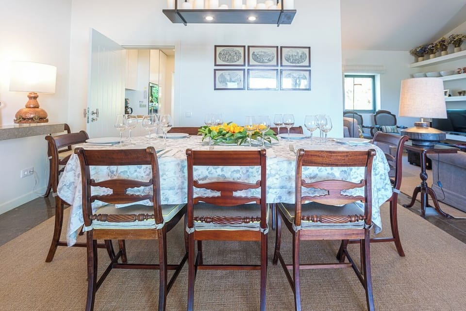 Elegant dining room with wooden chairs and yellow flowers — Villa Santamaria, luxury holiday villa in Sintra