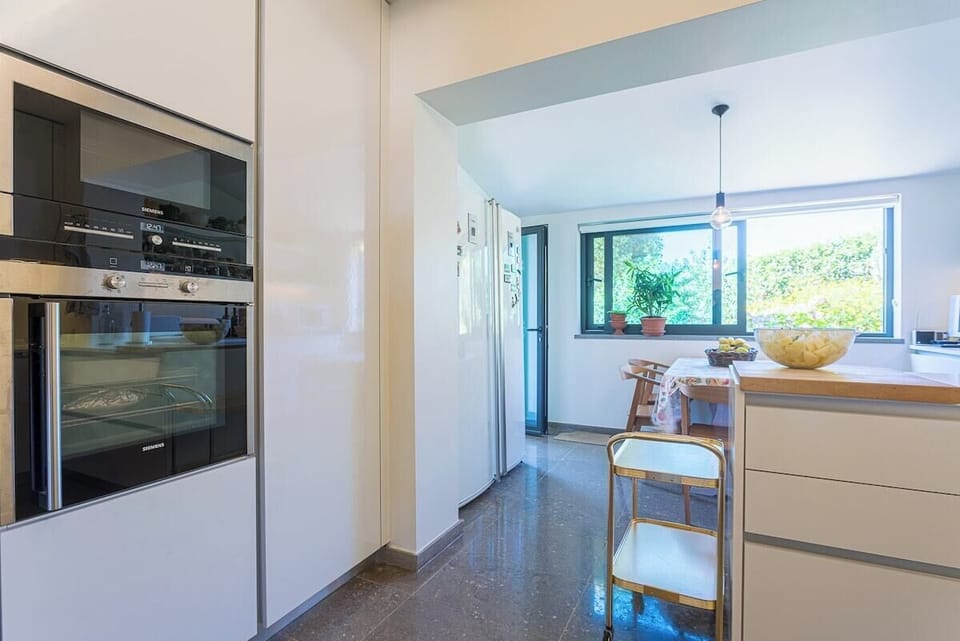 Modern kitchen with integrated appliances and garden views — Villa Santamaria, luxury holiday villa in Sintra