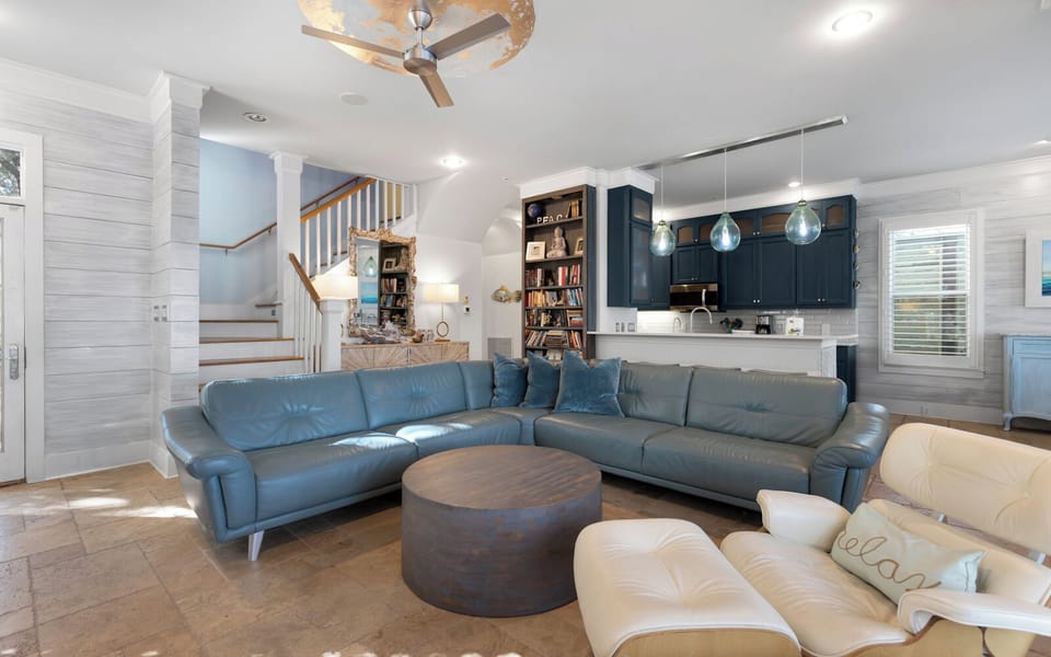 Sink into plush leather seating in your spacious open-concept living area, where coastal blues and warm wood create the perfect retreat.
