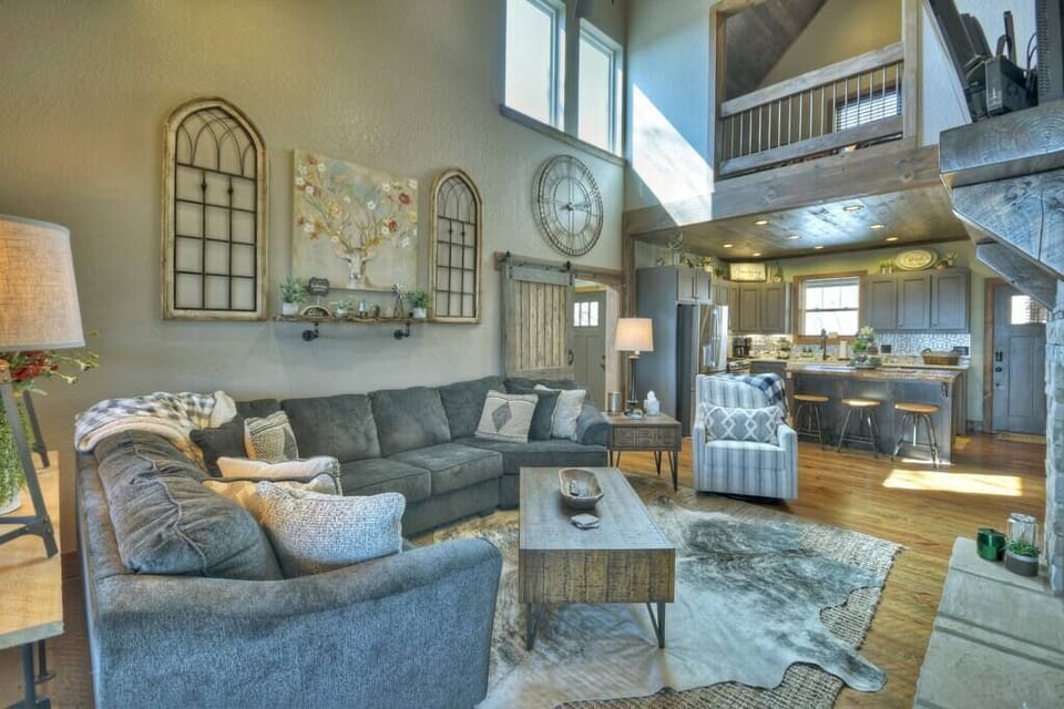 Luxurious living room with stone gas fireplace, smart/satellite TV, and cozy furniture