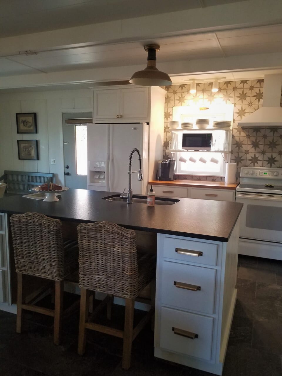 Kitchen has large island with leathered granite countertop and seating for 2