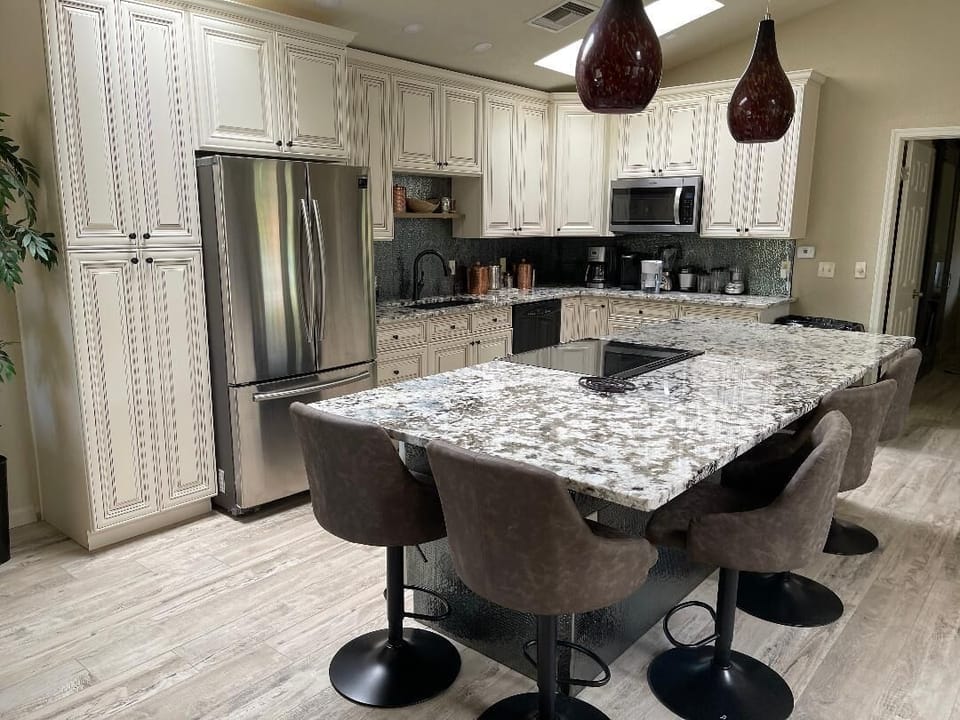 Cooktop on Granite Island with five leather chairs