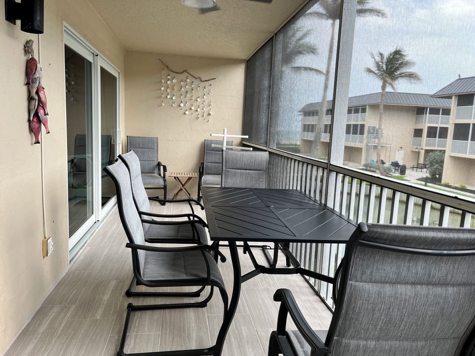 Screened Lanai Relaxation: Comfortable screened main lanai with dining furniture. Enjoy fresh air & views overlooking the Sanibel Siesta tropical pond area. Your private outdoor spot!