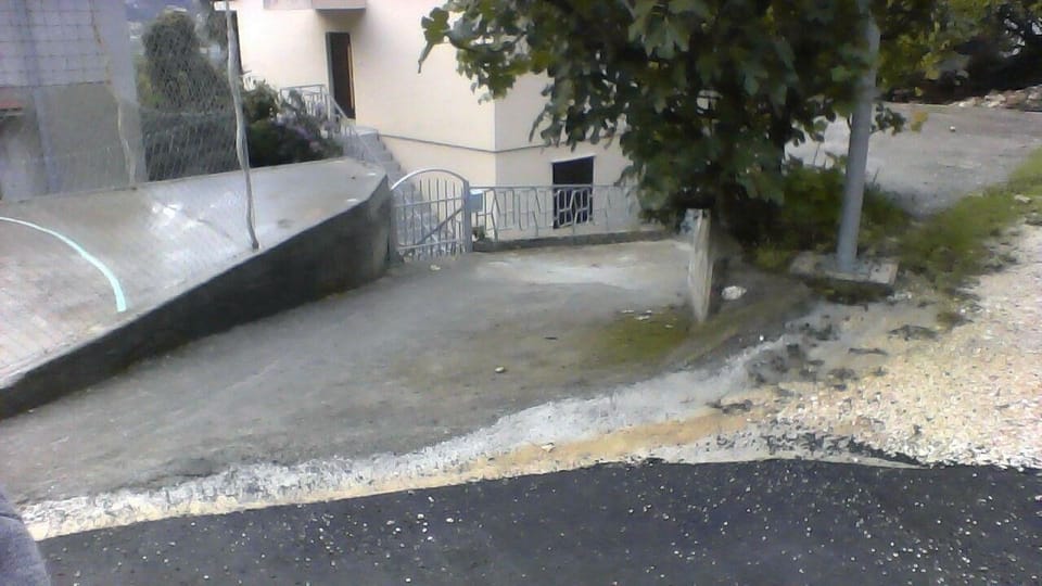 Area that directly surrounds the property. parking place next to the family house behind a lamppost and driveway