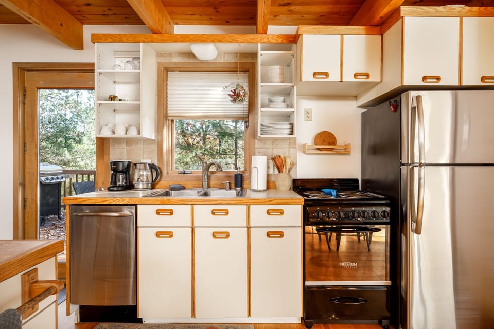 Bright kitchen w/ stainless steel appliances, wood accents & window views