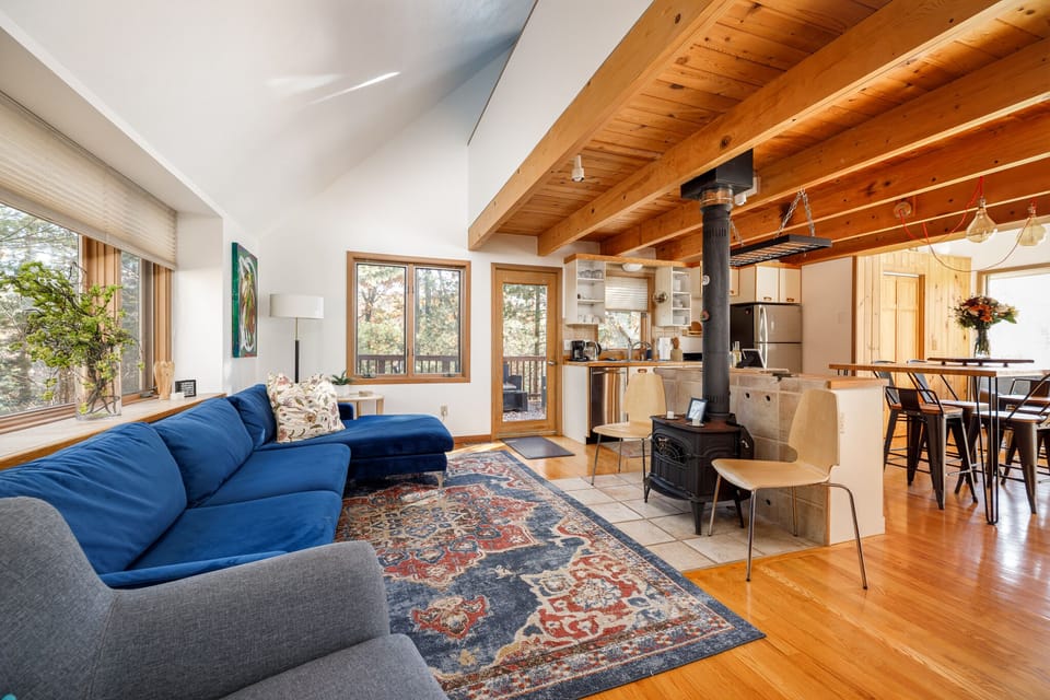 Open-concept living space w/ vaulted wood ceilings & seamless flow to dining