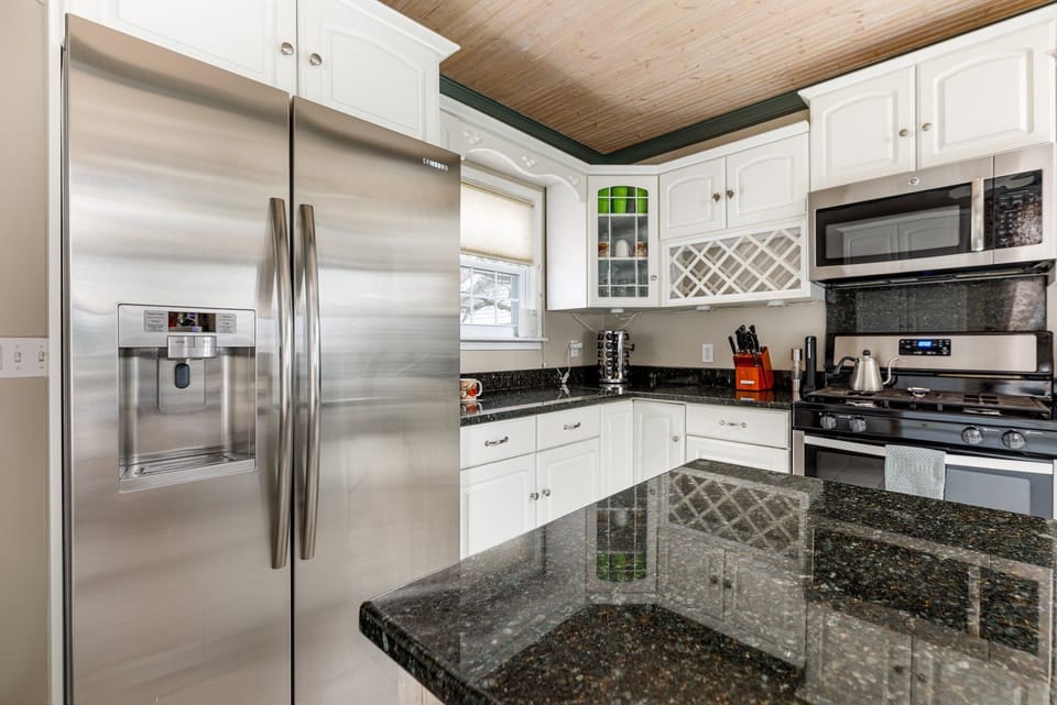 Modern kitchen w/ granite counters, stainless steel appliances & ample prep space for easy meals.
