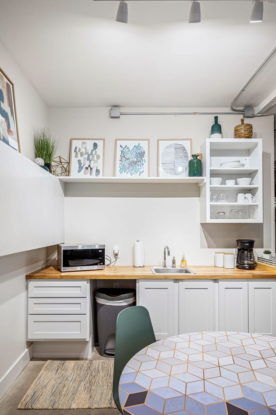Handy kitchenette w/ mini fridge, microwave & open shelving for easy snacks & coffee breaks.