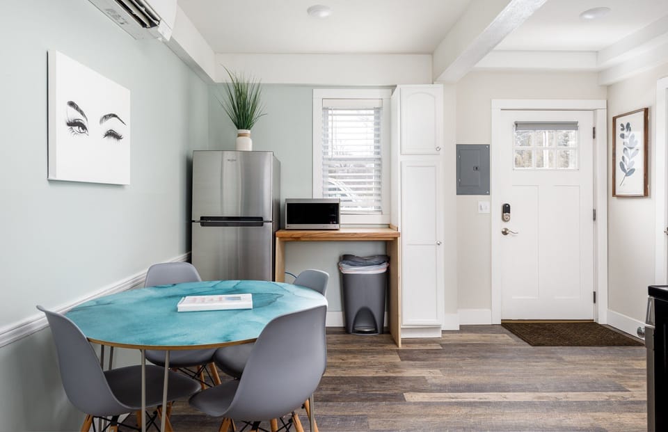 Cozy dining nook by the kitchen w/ stainless fridge & natural light