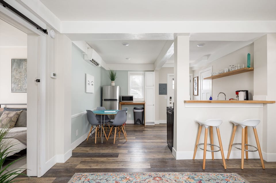 Open-concept layout w/ breakfast bar seating & dining area beyond