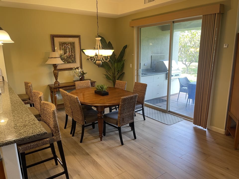 Dining room next to outside lanai that has built-in Viking grill