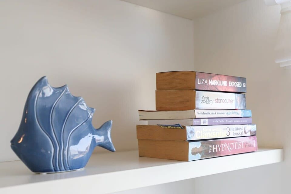 A shelf in the living room with decorative items, books, and neatly placed objects.