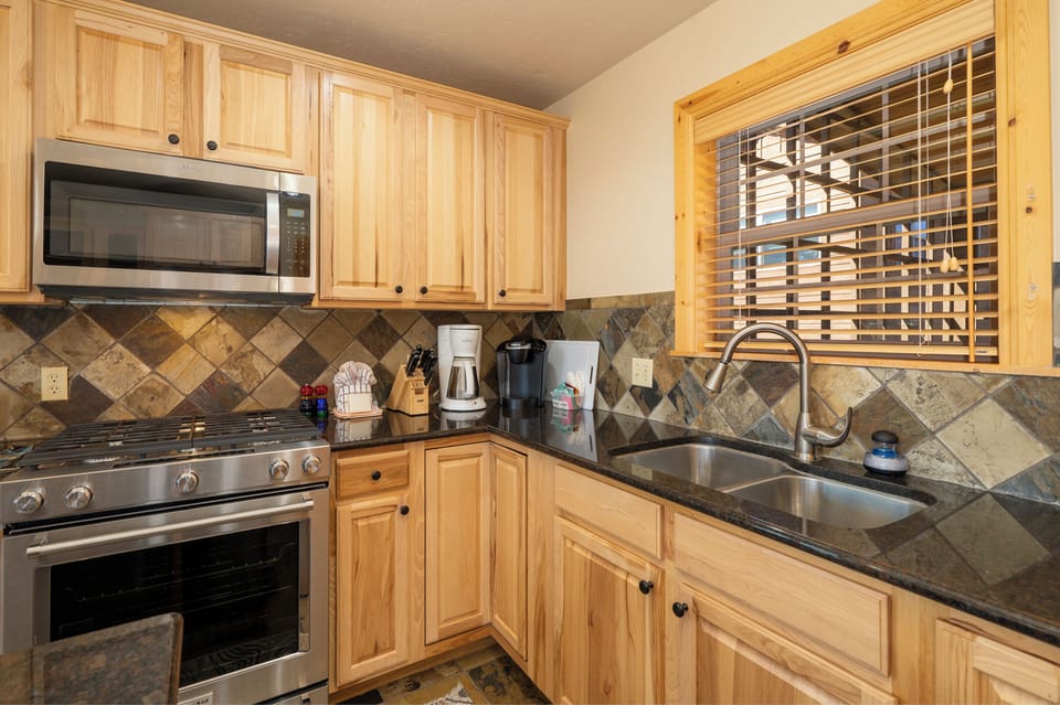 Cook your favorite meals in this fully equipped kitchen with granite counters, stainless appliances, and warm wood cabinets.