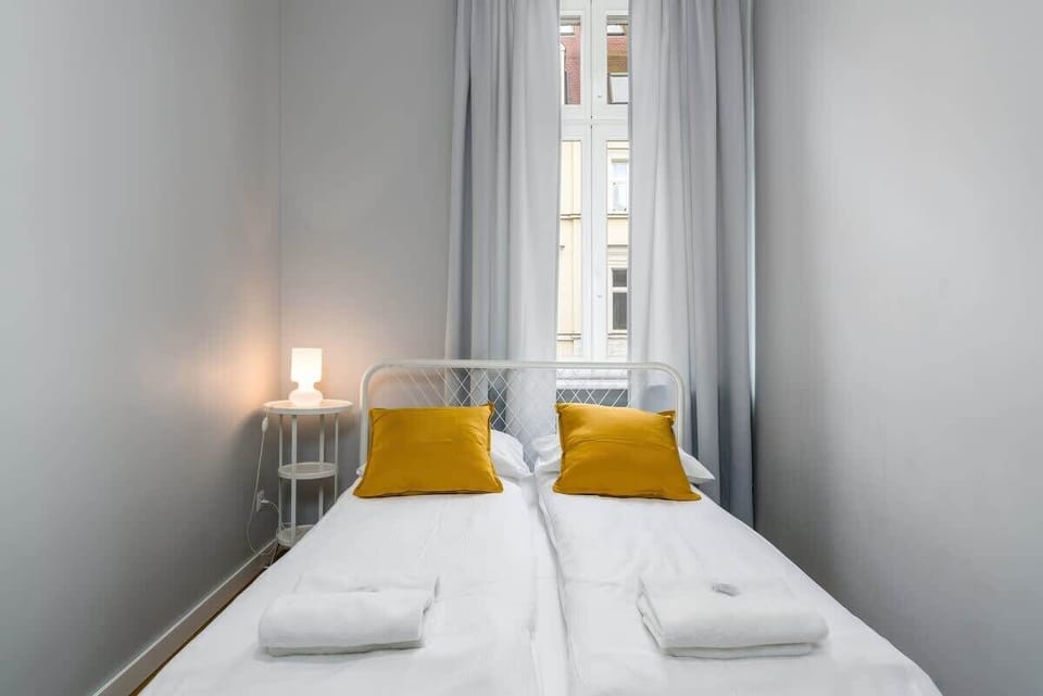 A cozy bedroom with double bed, yellow pillows, and white bedding.
