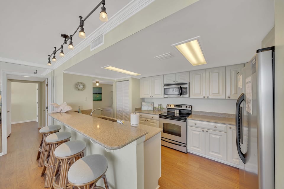 There is a dining table, perfect for enjoying a meal or playing a game, as well as additional breakfast bar seating.