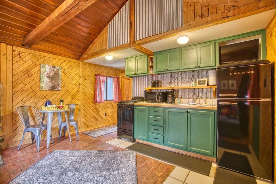 Inviting great room with vaulted ceiling and SmartTV. Enjoy the antique wood burning stove and complimentary firewood during your stay.