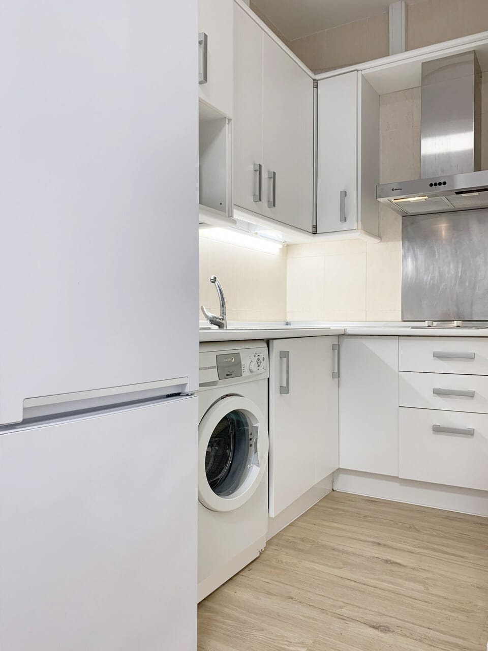 Cozy kitchen with stove, refrigerator, storage and washing machine