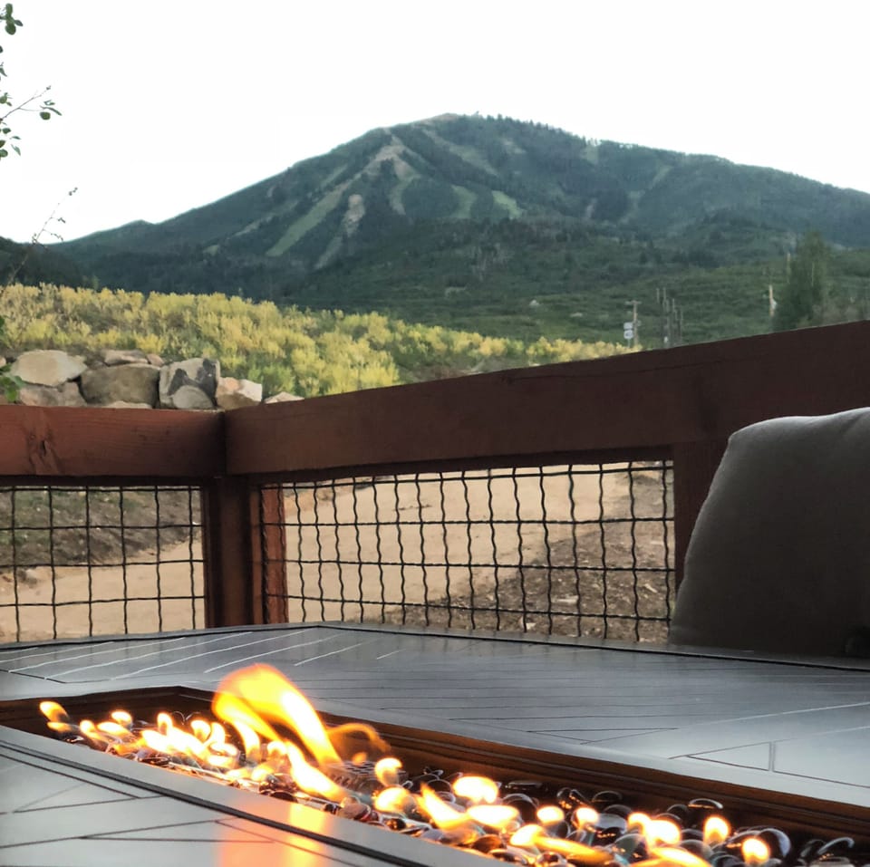 Large outside table on the balcony, with a fire pit.
