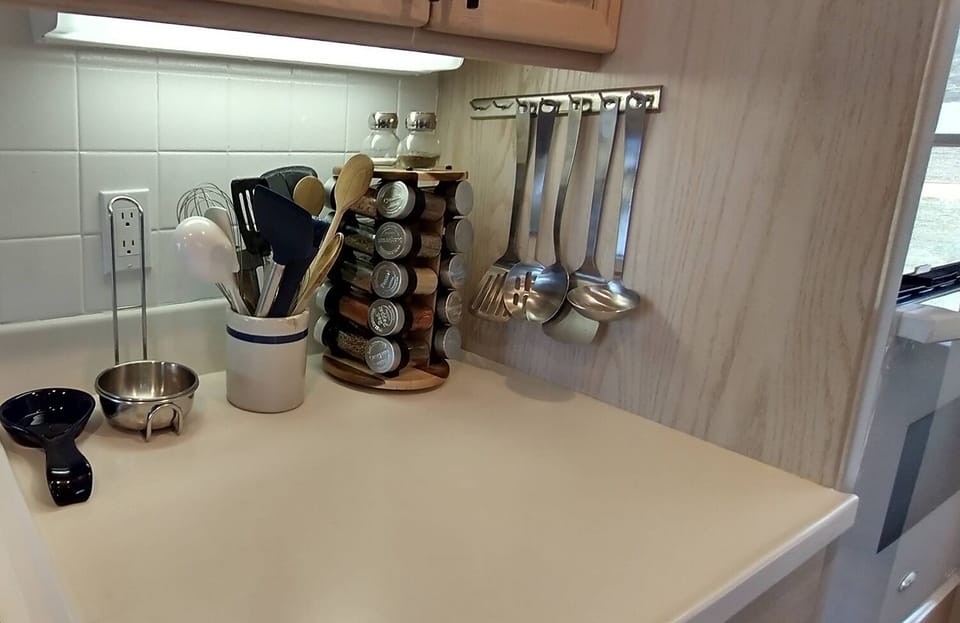 A full spice rack and every cooking utensil imaginable. This kitchen is stocked!