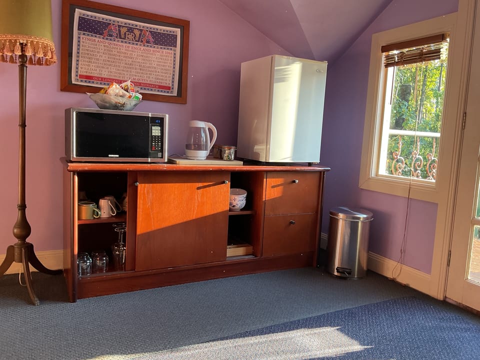 Kitchenette with microwave, kettle, fridge, crockery and cutlery
