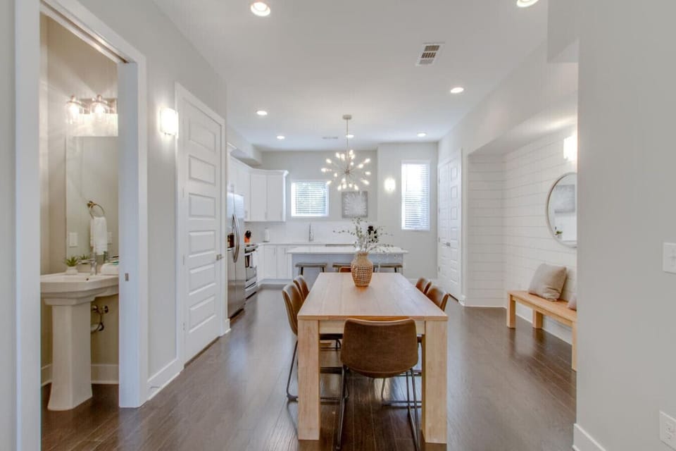 Elegant dining area with a long wood table, statement chandelier, and open layout
