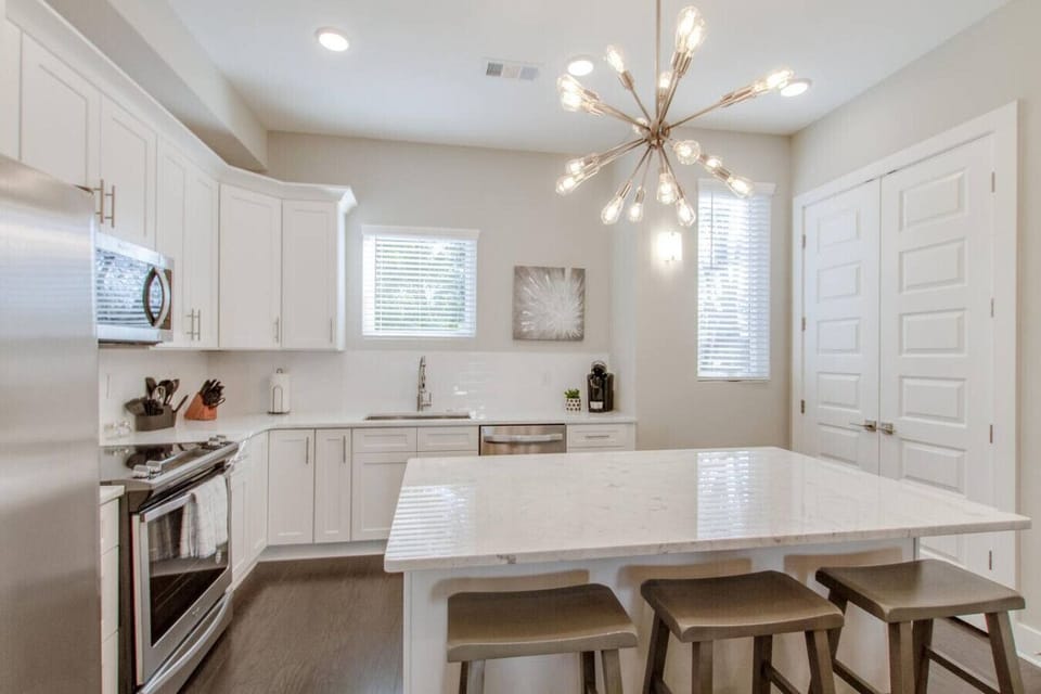 Gourmet kitchen featuring an island, chandelier lighting, and bright white cabinetry