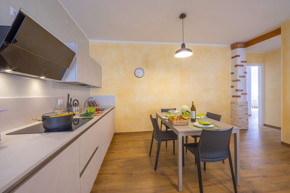 The living room with dining table and view of the kitchen