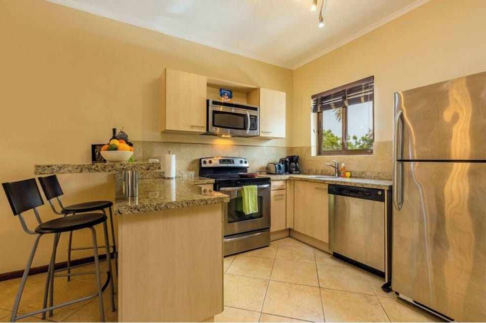 Well equipped kitchen with coffee maker, microwave, dishwasher, fridge, oven, and stove.