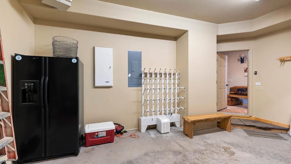 2 car garage with extra refrigerator, industrial boot warmer system, and tons of ski racks