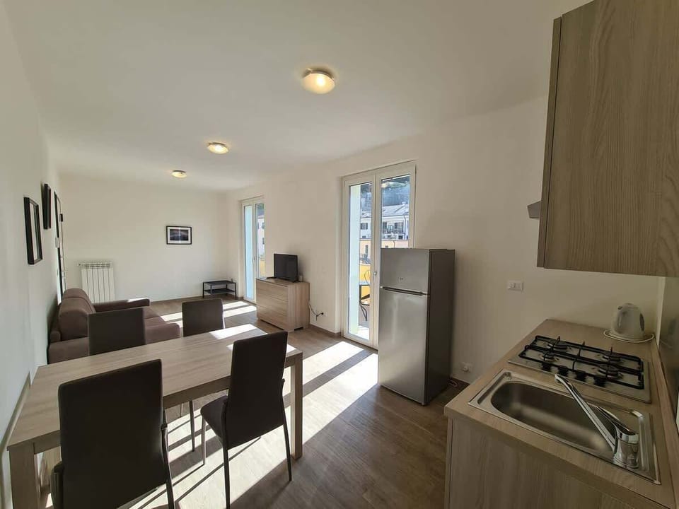 soggiorno cucina e accesso al balcone privato con tavolo e sedie