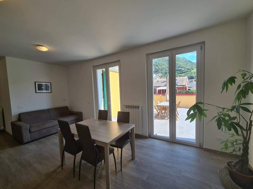 soggiorno e accesso a terrazzo privato con sedie, tavolo , sdraio e ombrellone