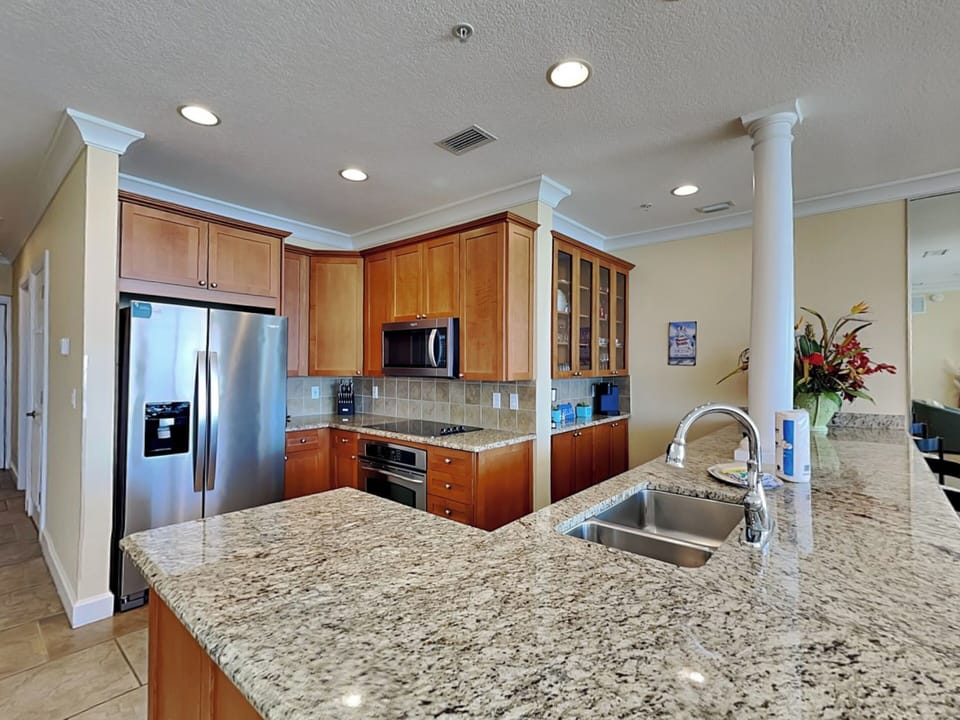 Fully Equipped Kitchen with Bar Seating and Stainless Steel Appliances