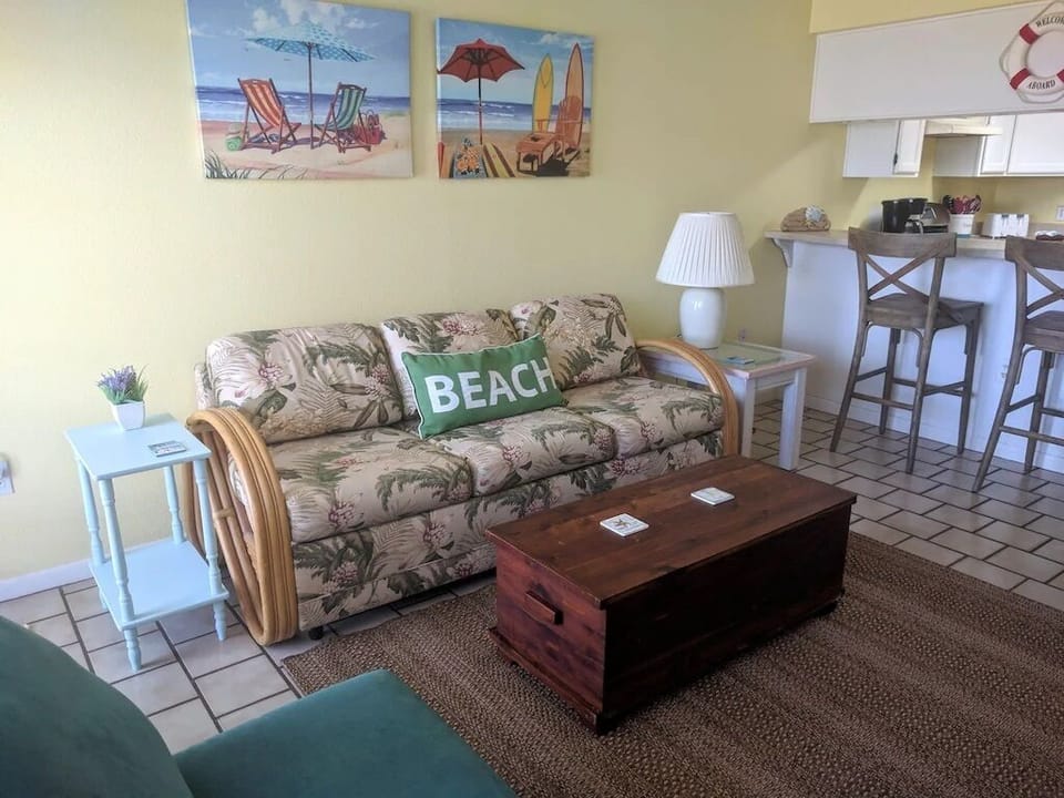 Queen size fold out couch in living area across from large TV mounted on wall.