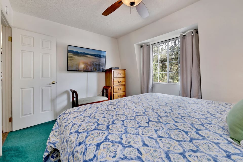 Peaceful cabin bedroom with plush bedding, and beautiful views—ideal for restful nights, cozy mornings, and a relaxing mountain escape.