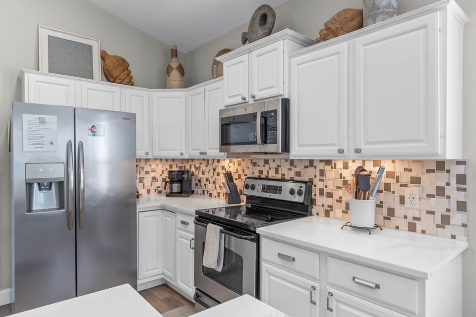 Bright modern kitchen with stainless appliances and stylish tile backsplash
