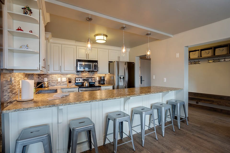 Your spacious kitchen features granite counters, stainless appliances, and bar seating perfect for morning coffee or evening conversations.