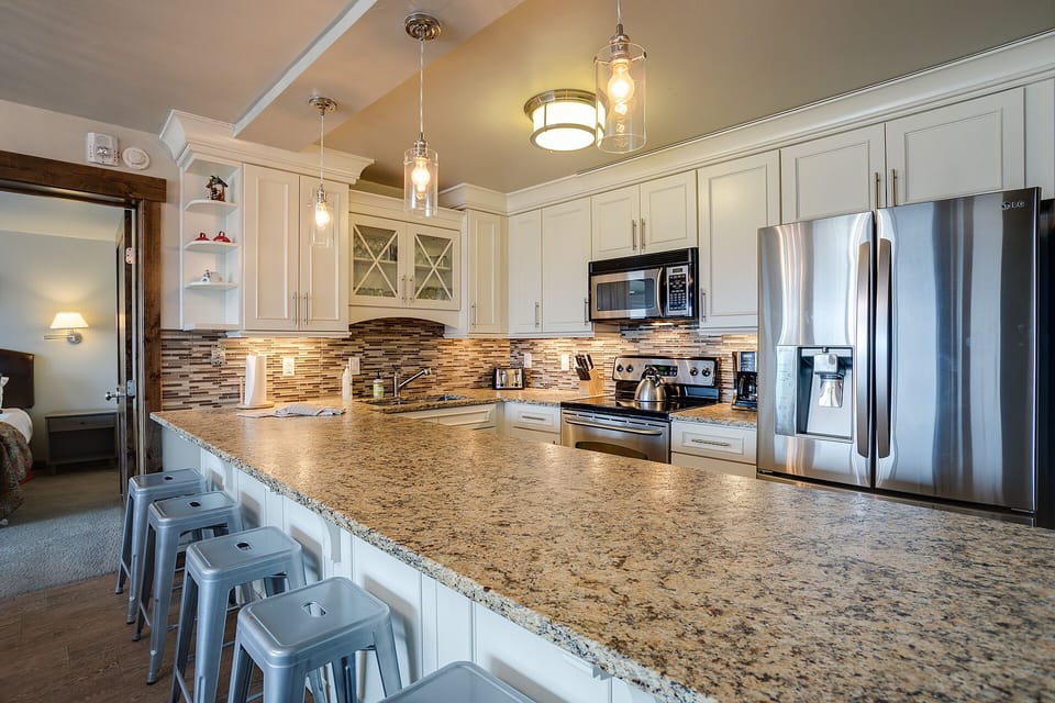 Your gourmet kitchen sparkles with granite counters, stainless appliances, and warm pendant lighting—perfect for creating memorable meals together.