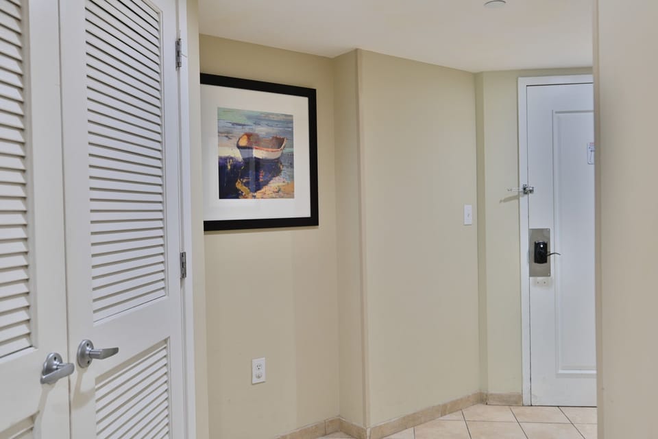 Bright entryway with tile floors, coastal art, and a clean, modern feel.