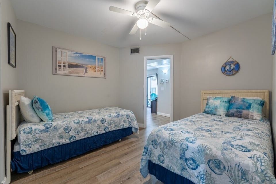 Charming twin bedroom with ocean-themed decor, ideal for relaxing.