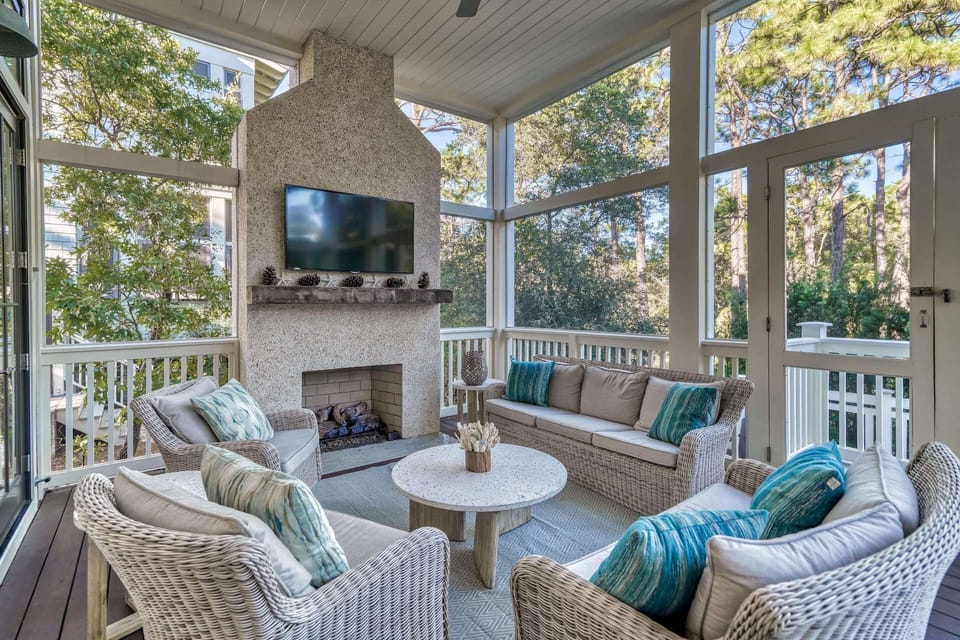 Screened-in outdoor lounge with fireplace and TV