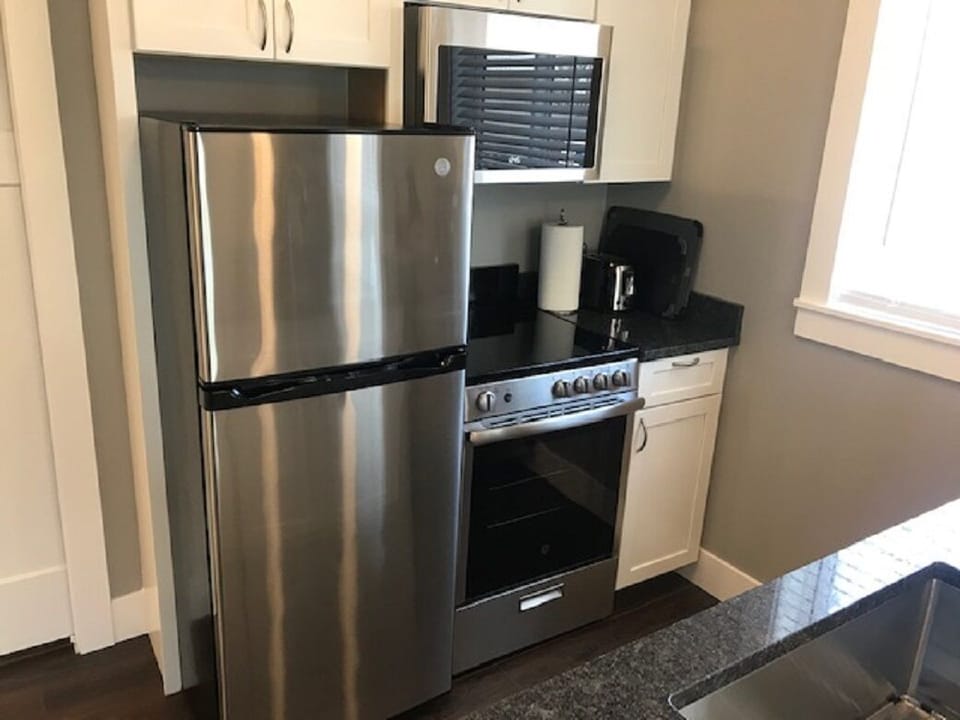 The kitchen has a refrigerator, stove/oven, microwave and dishwasher