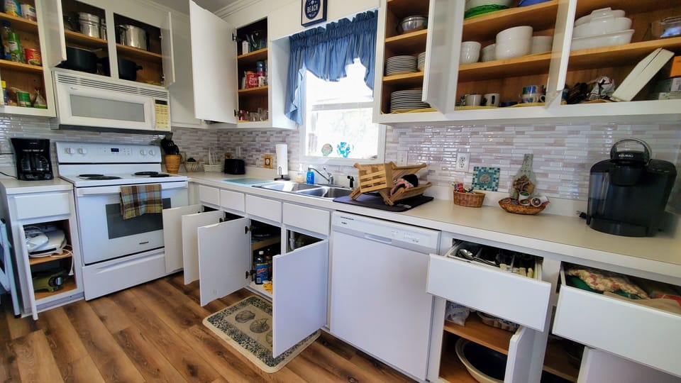 The kitchen is fully stocked with pots, pans, plates, mugs, new appliances, etc.