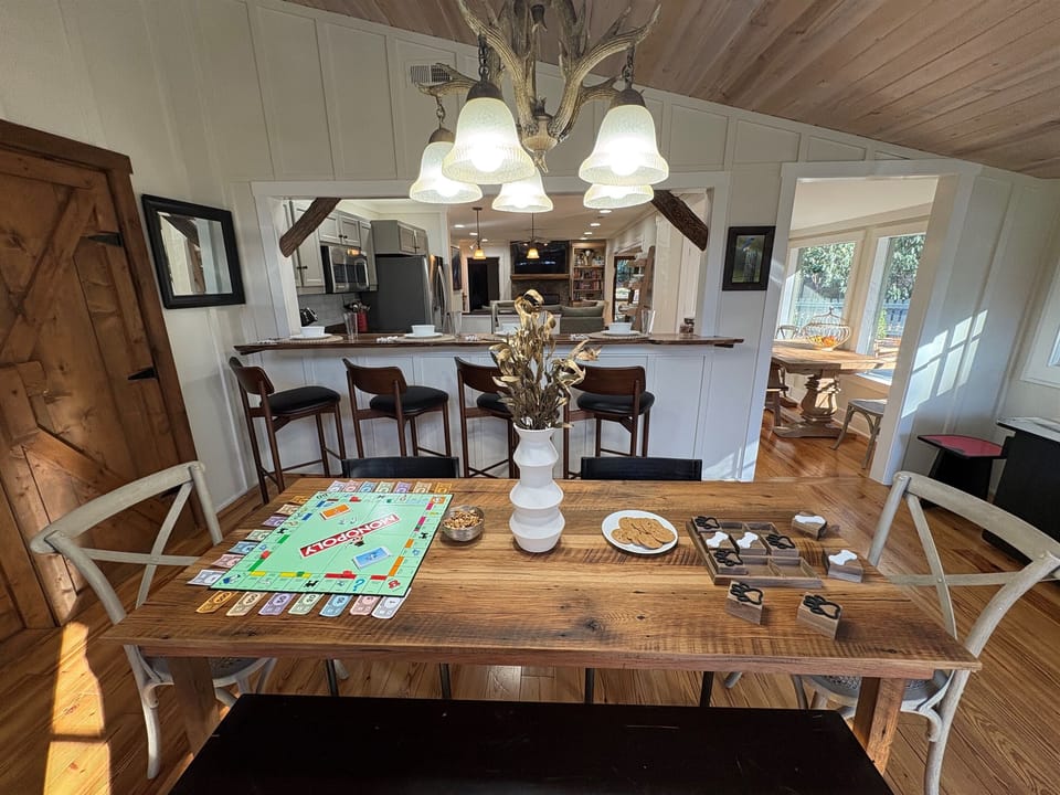 Gather around the spacious farmhouse table for games, snacks, and cozy connection just steps from the kitchen and sunlit dining nook.