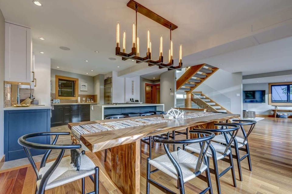 Dining area with custom-built wooden table and matching chandelier