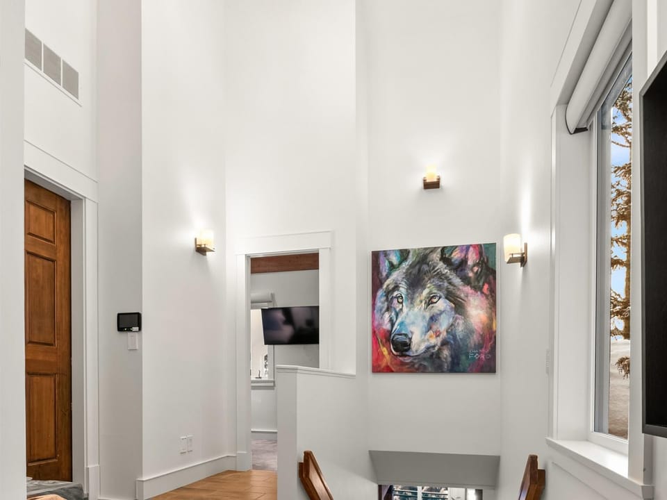 Entryway with stairs down to main level filled with local art