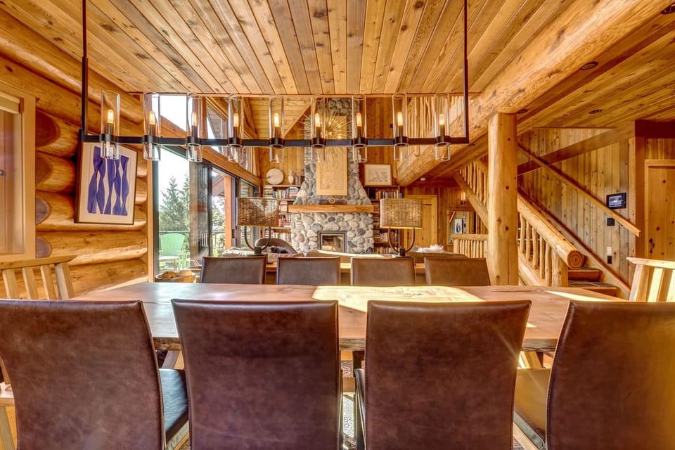 Modern log cabin dining with leather chairs and large wooden table