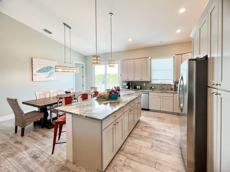 Welcome to the heart of Green Tortuga, where the kitchen, dining, and living room converge in a harmonious dance of open space. This seamless design invites connection, conversation, and the free flow of moments in a space where every corner feels like hom