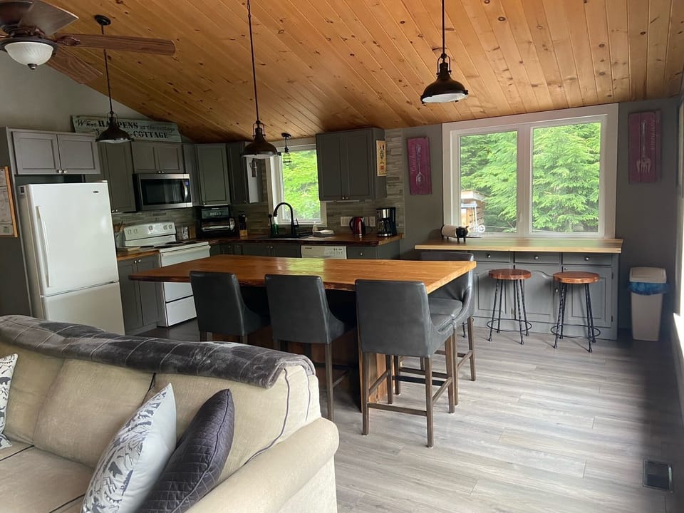 Open concept main floor living room and fully-equipped kitchen.