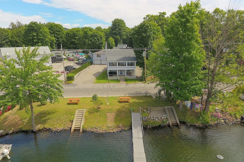 The Inn at Highland Lake with waterfront yard across street with a dock