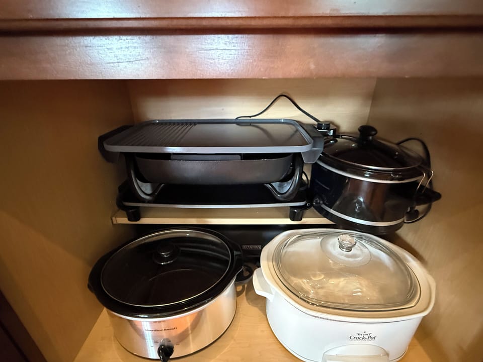 Three crockpots and three skillets. 